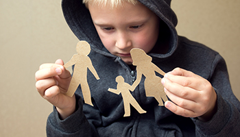 A kid playing with a family made of paper